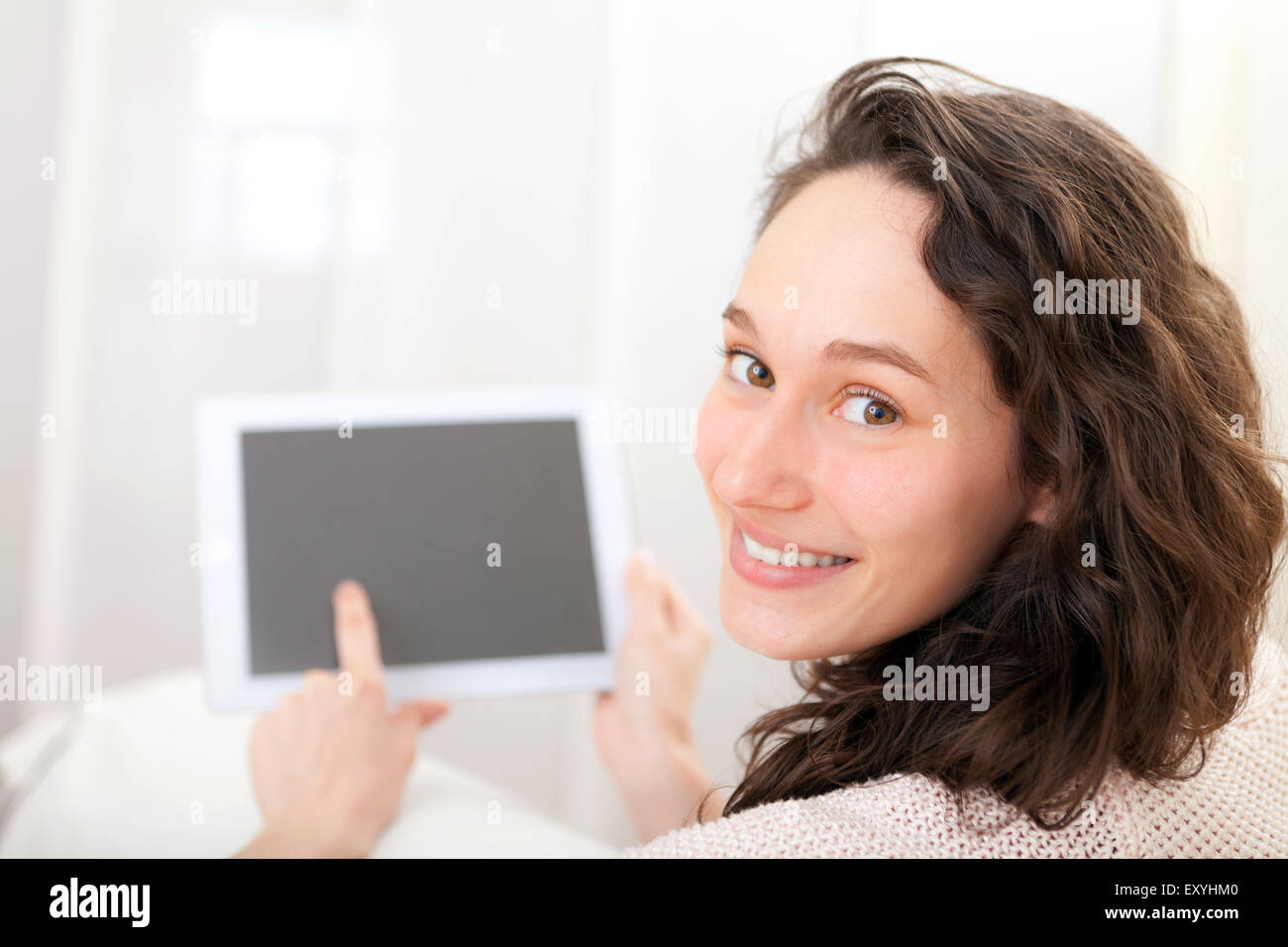 Vista de una joven mujer atractiva con tablet de sofá Foto de stock