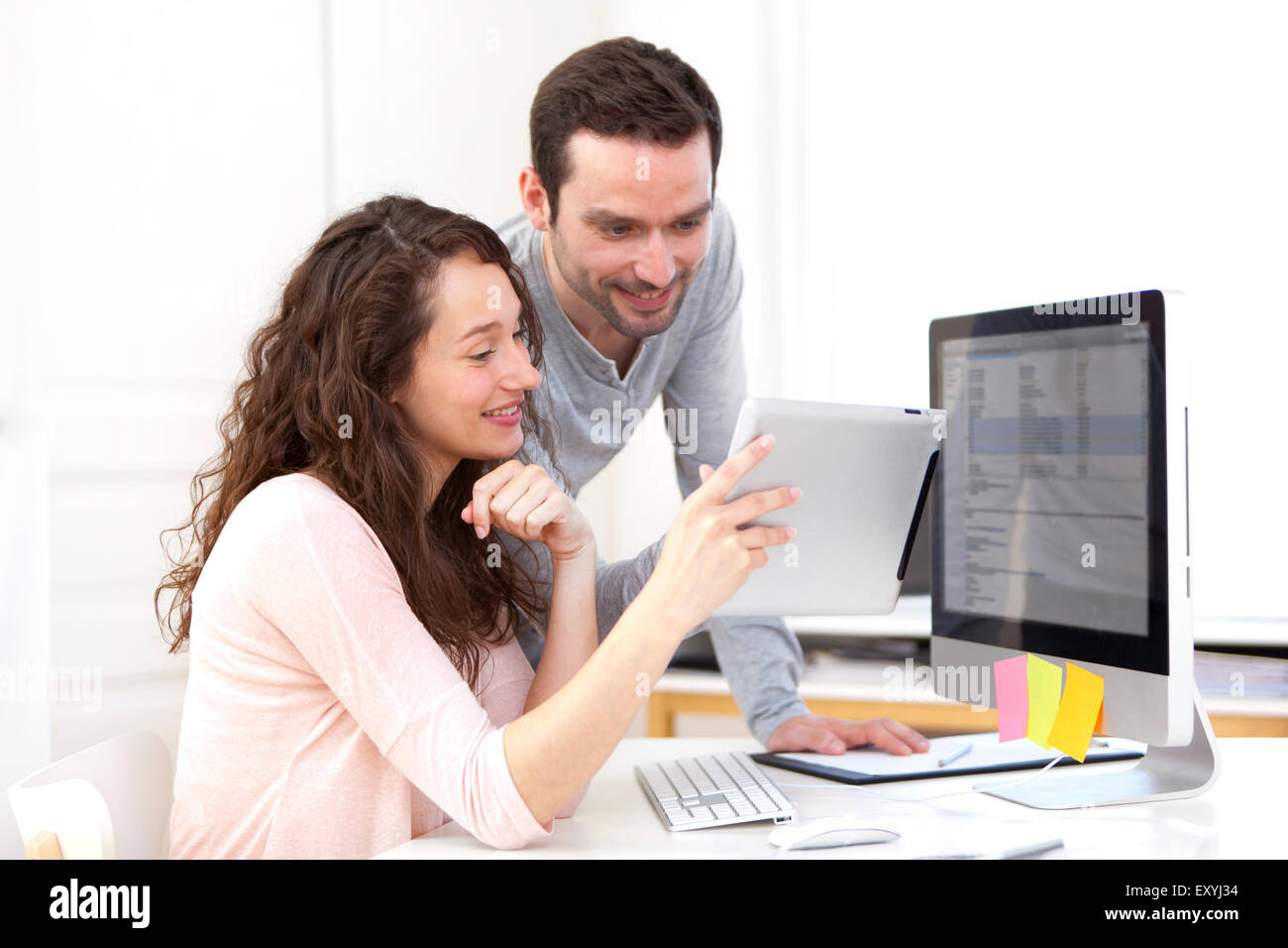 Vista de la mujer que trabaja en tablet con su compañero Foto de stock