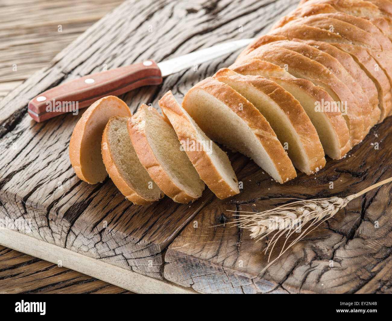 Rodajas de pan blanco sobre la plancha de madera vieja. Foto de stock