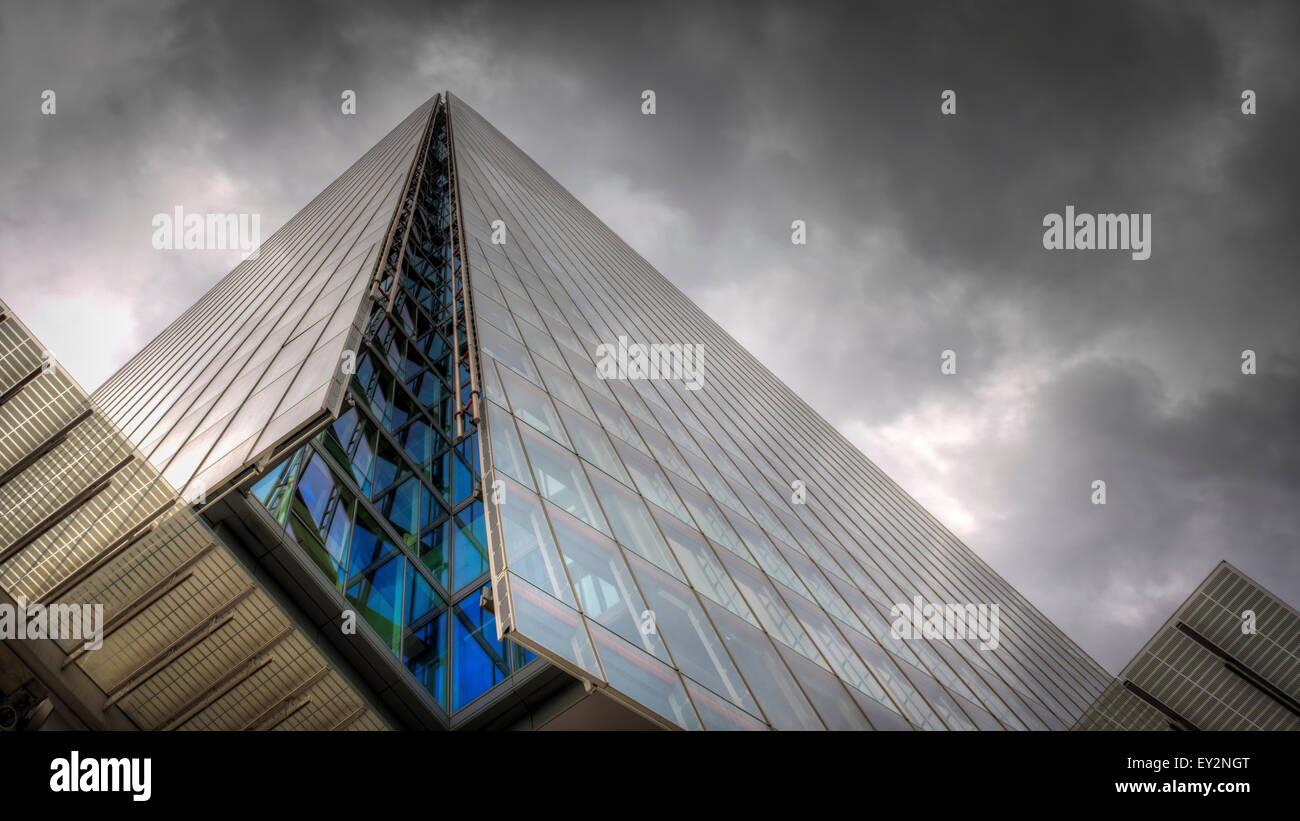 La icónica Shard en Londres visto desde la base mirando hacia uno de los lados del edificio moderno de vidrio en un día nublado nublado Foto de stock