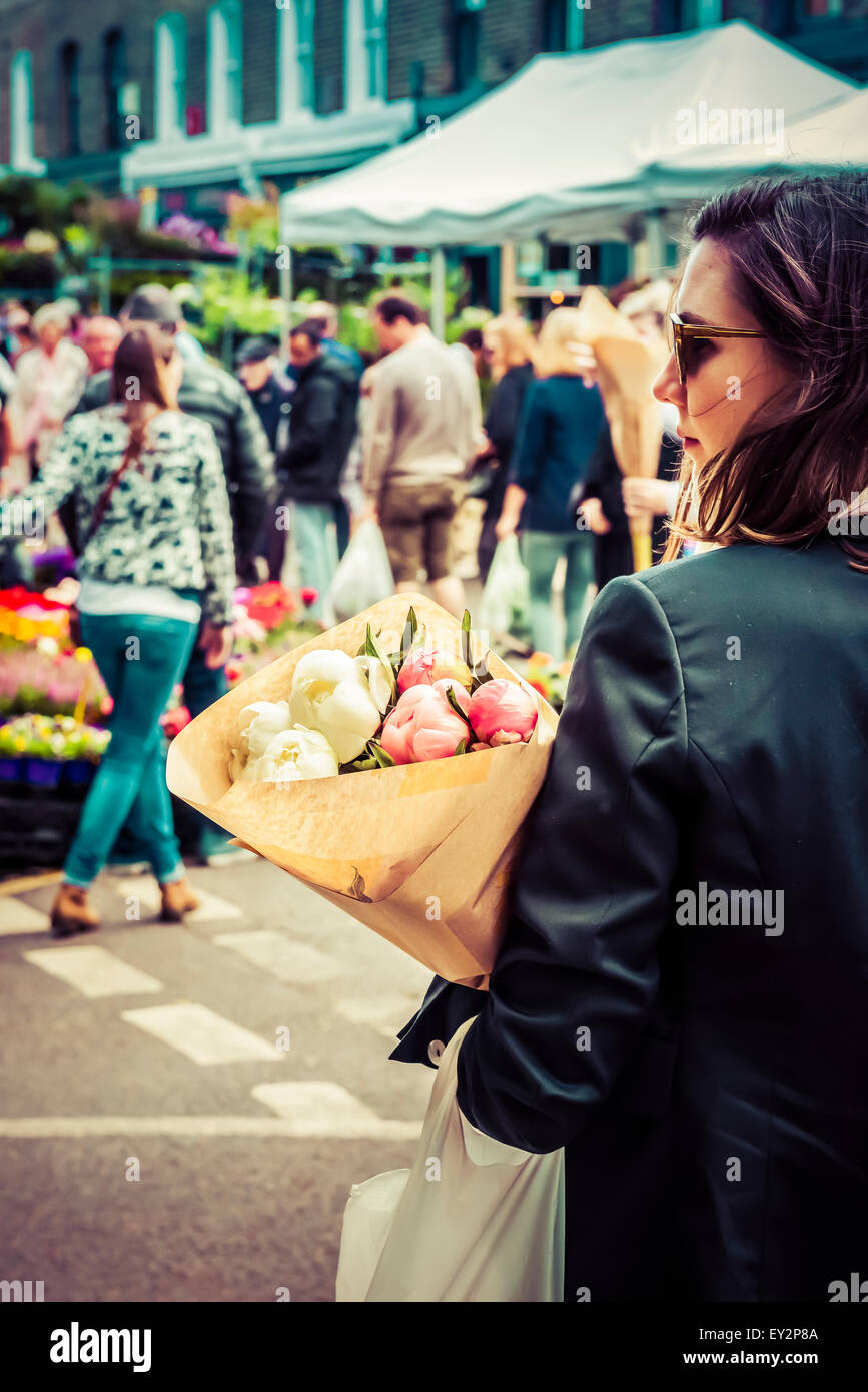 Una señora llevando un ramo de flores frescas en el mercado de las flores Foto de stock