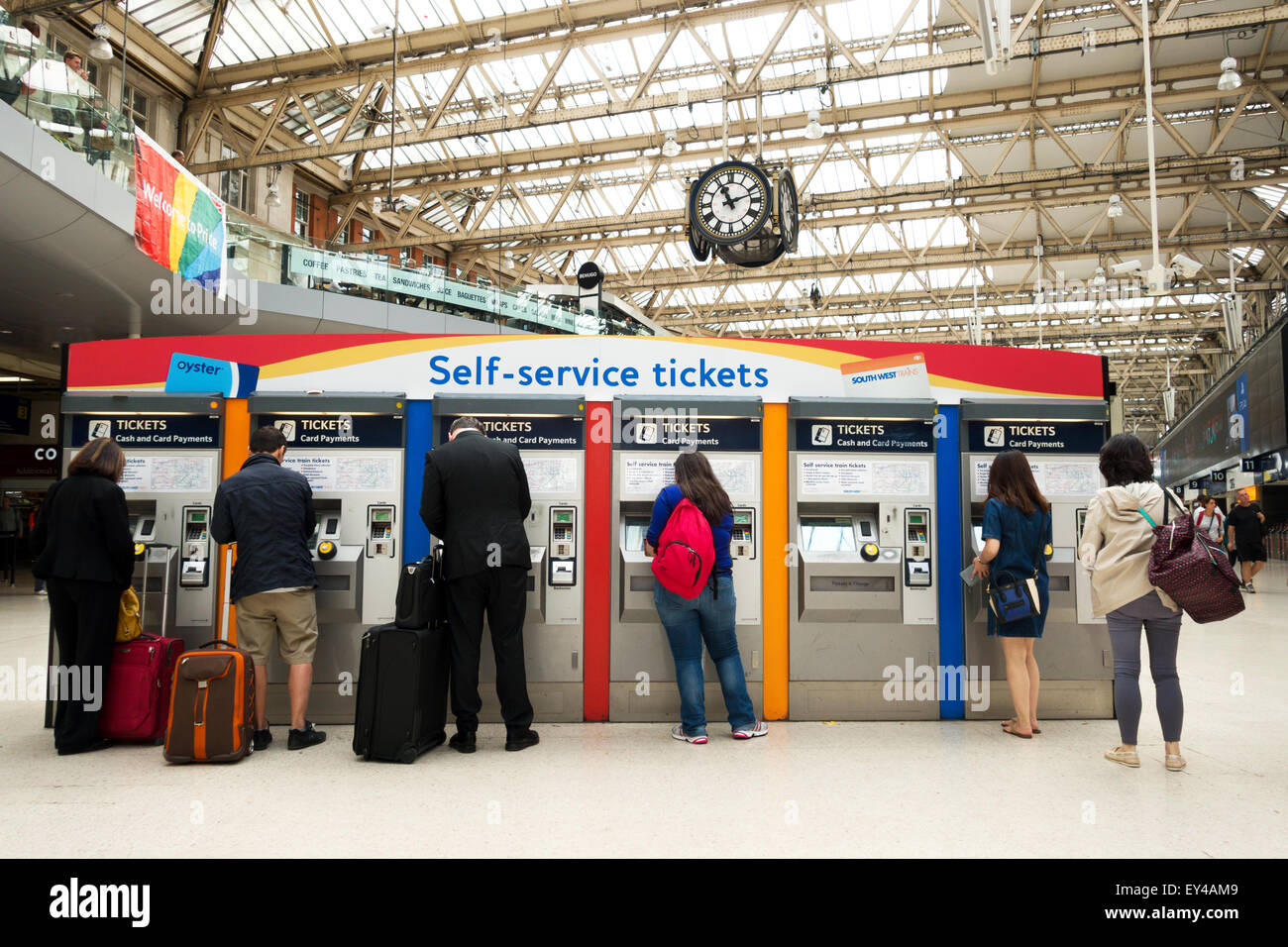 Las personas que compran billetes de tren desde un autoservicio de taquilla, la estación de tren de Waterloo, Londres, Gran Bretaña. Foto de stock