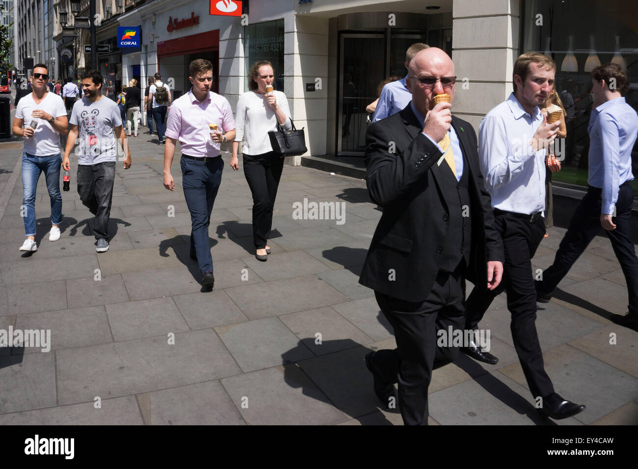 Comen helado en Londres, Reino Unido. Este grupo de trabajadores de la ciudad están todos felices comiendo sus helados en un caluroso día de verano. Foto de stock