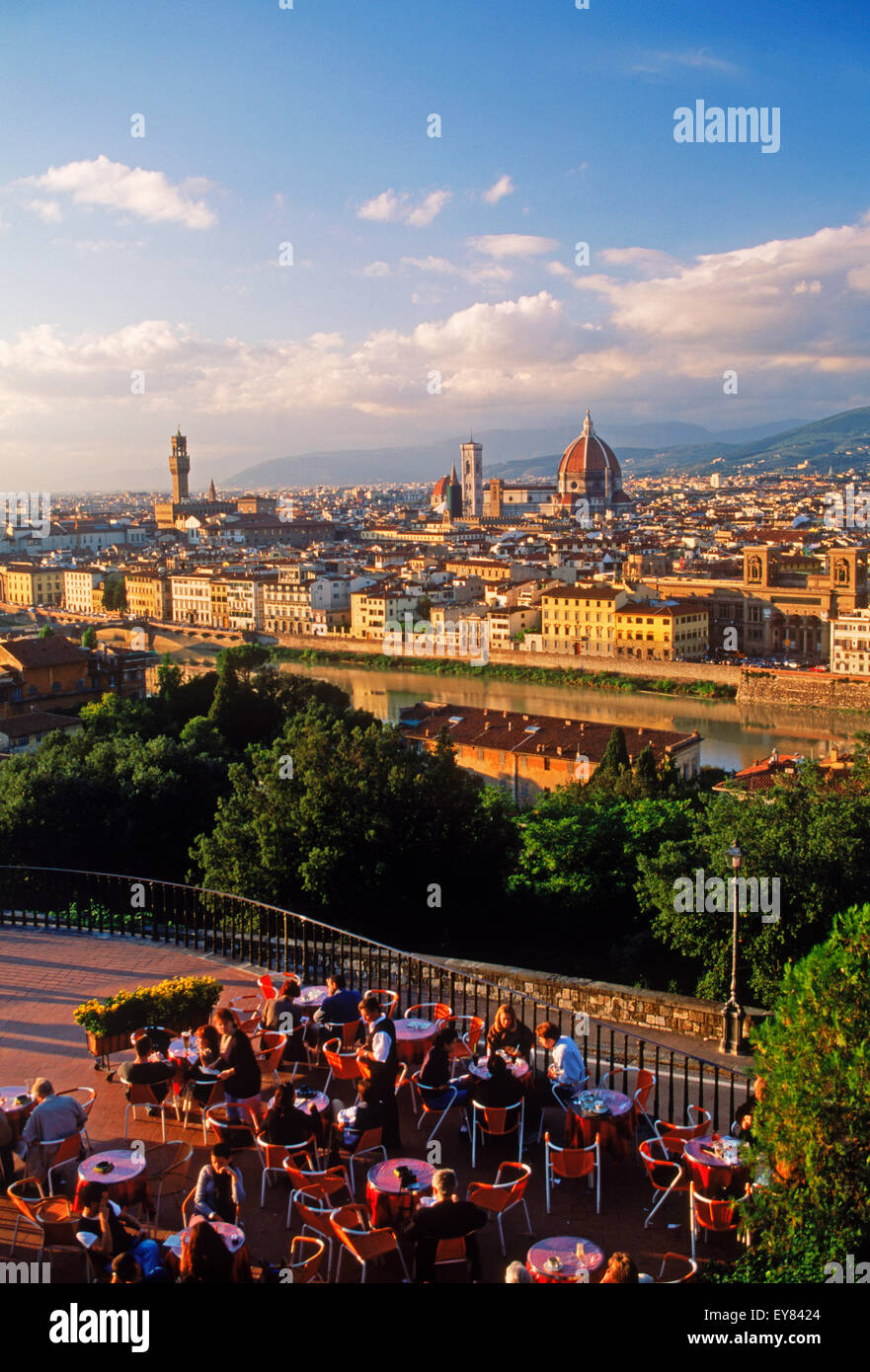 Personas y mesas de café al aire libre en el Piazzale Michelangelo (Plaza) por encima del río Arno y Florencia cerca del atardecer Foto de stock