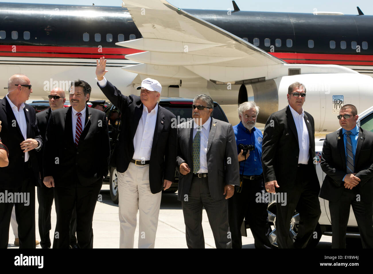 El candidato presidencial estadounidense Donald Trump las olas a los seguidores con el grupo local de Laredo, Texas, dignatarios después de aterrizar su avión privado en el aeropuerto el 23 de julio, 2015 Foto de stock