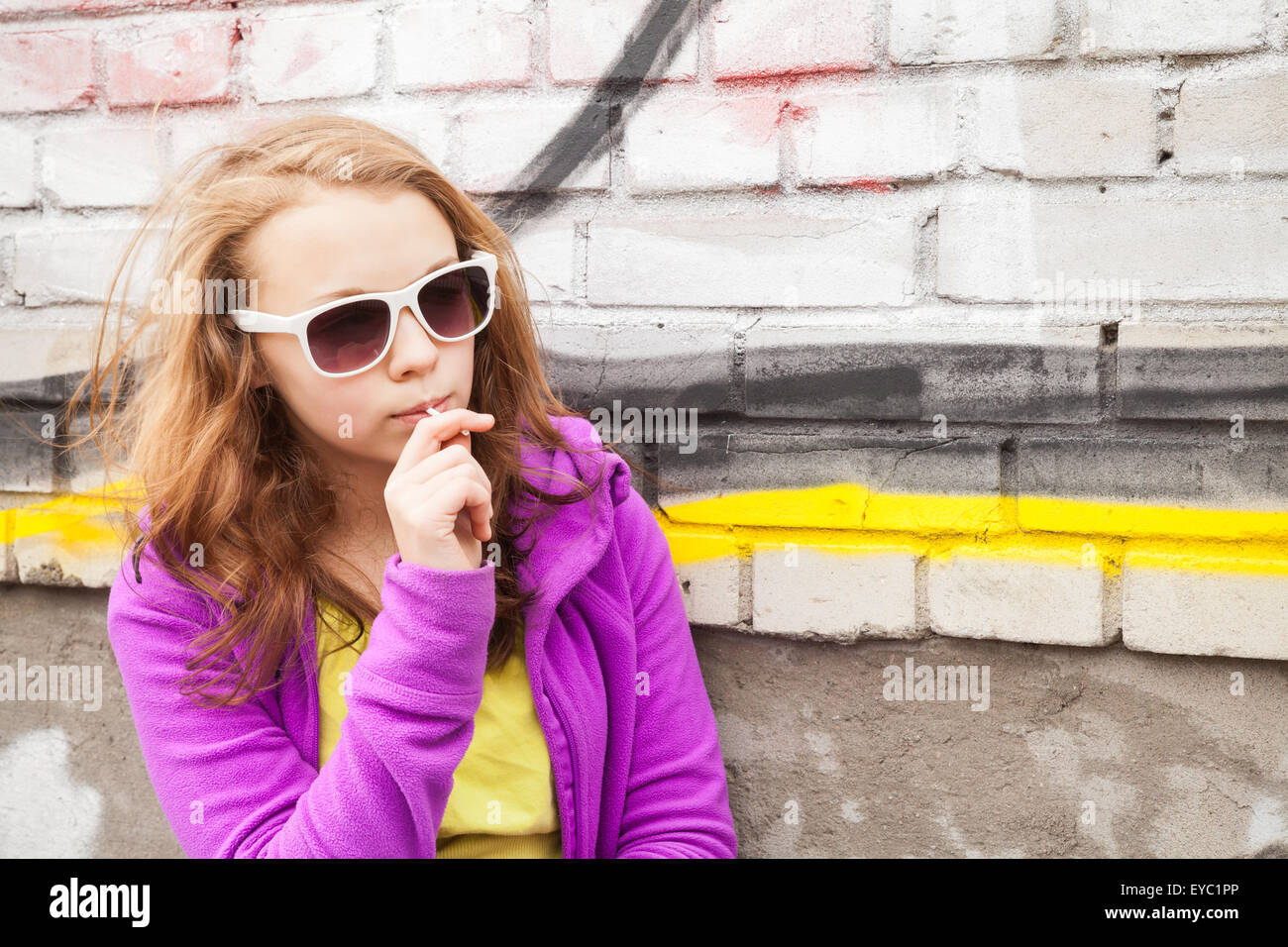 Rubia adolescente con lollipop, retrato urbano vertical exterior Foto de stock