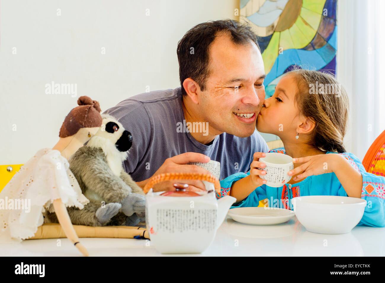 Padre niñas besos en la mejilla a la mesa Foto de stock