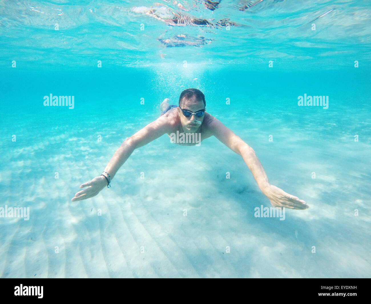 Nadar bajo el agua en un mar claro Foto de stock