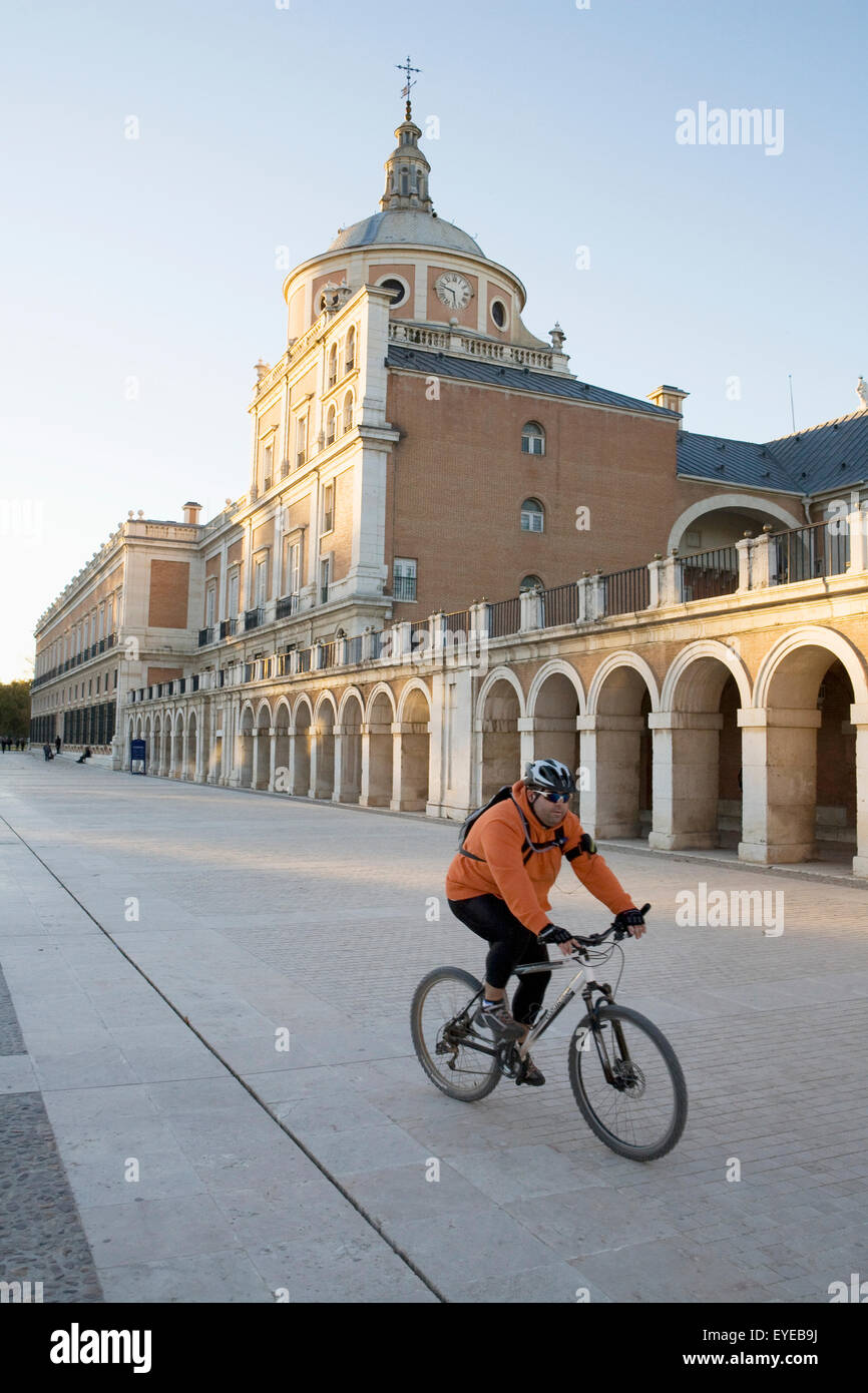 España, ciclista pasando por el Palacio Real de Aranjuez. Foto de stock