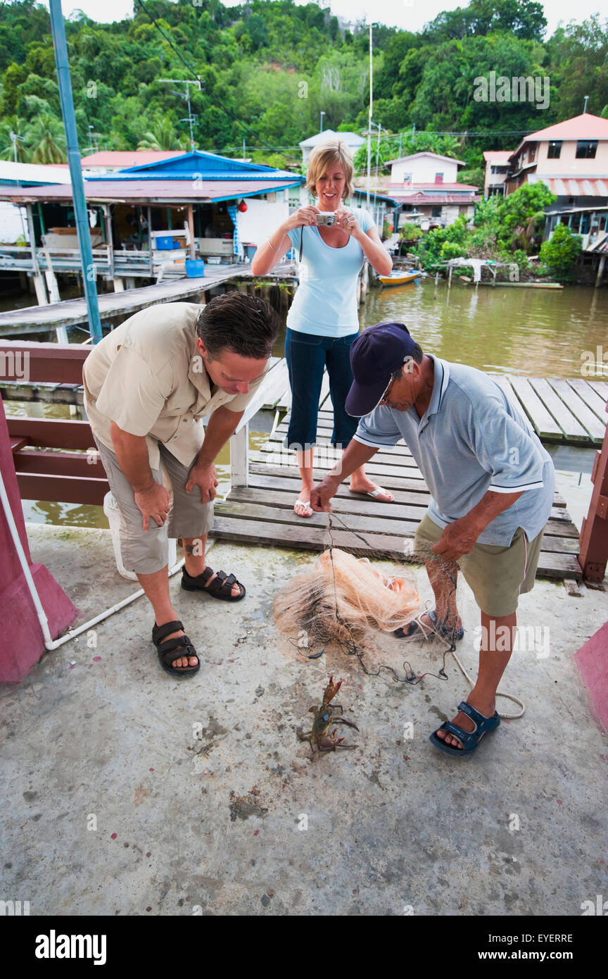 Los turistas practican su red en una pequeña aldea pesquera; Brunei Foto de stock