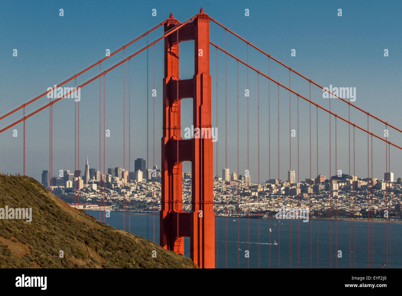 Una de las enormes torres naranjas del Golden Gate Bridge desde el Marin Headlands, con la ciudad DE San Francisco en la distancia, California, Estados Unidos Foto de stock