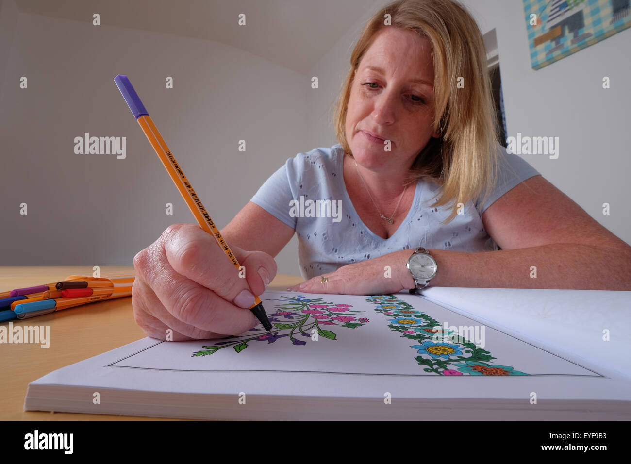 Una mujer adulta colorear un libro de colorear diseño vintage, una nueva tendencia en la relajación para adultos Foto de stock