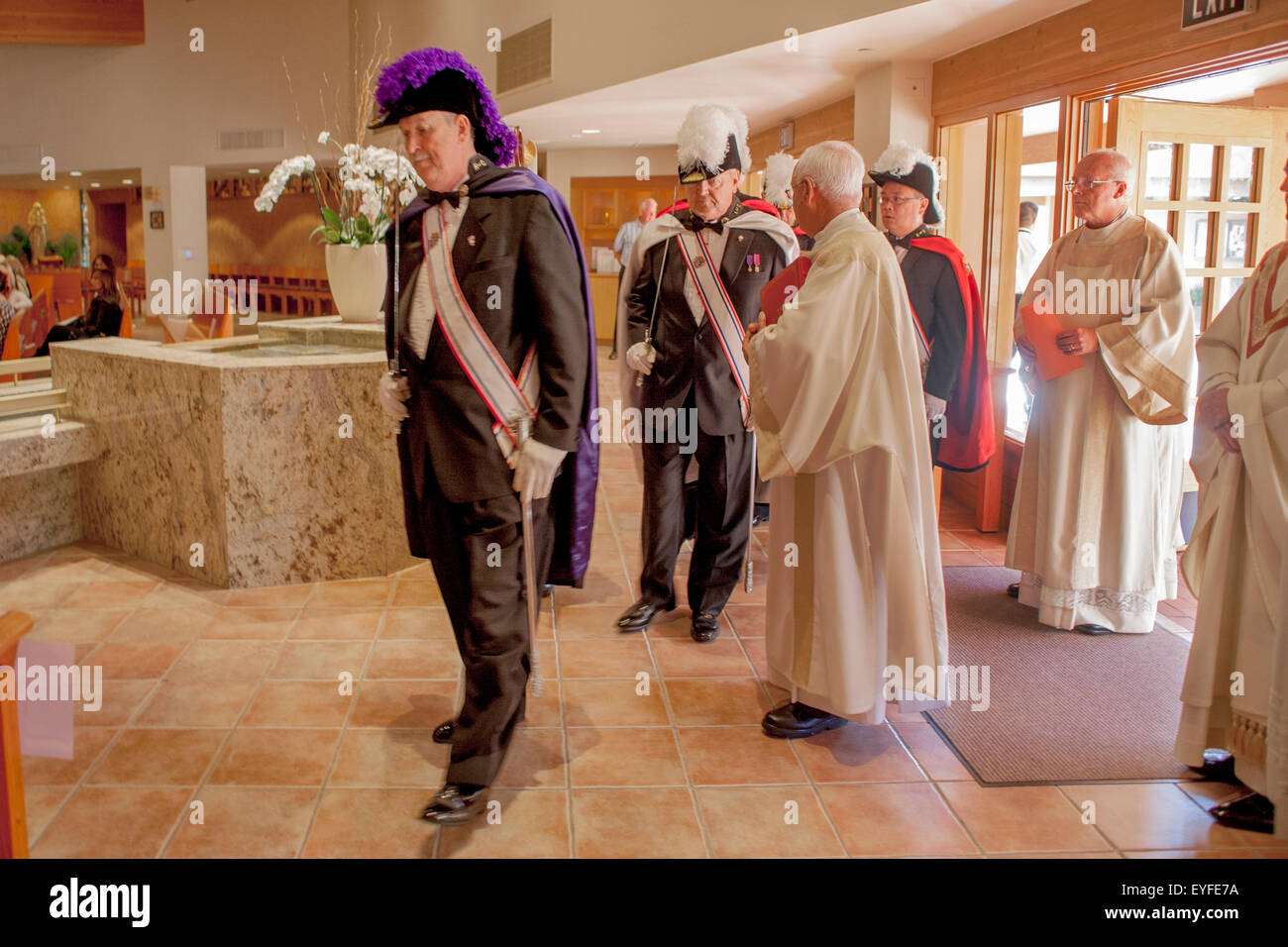 Vestidos con sus uniformes oficiales ornamentados y llevar espadas, cuarto  grado de miembros de los Caballeros de Colón llegan a una Laguna Niguel,  CA, Iglesia Católica para ceremonias de confirmación. Nota agua