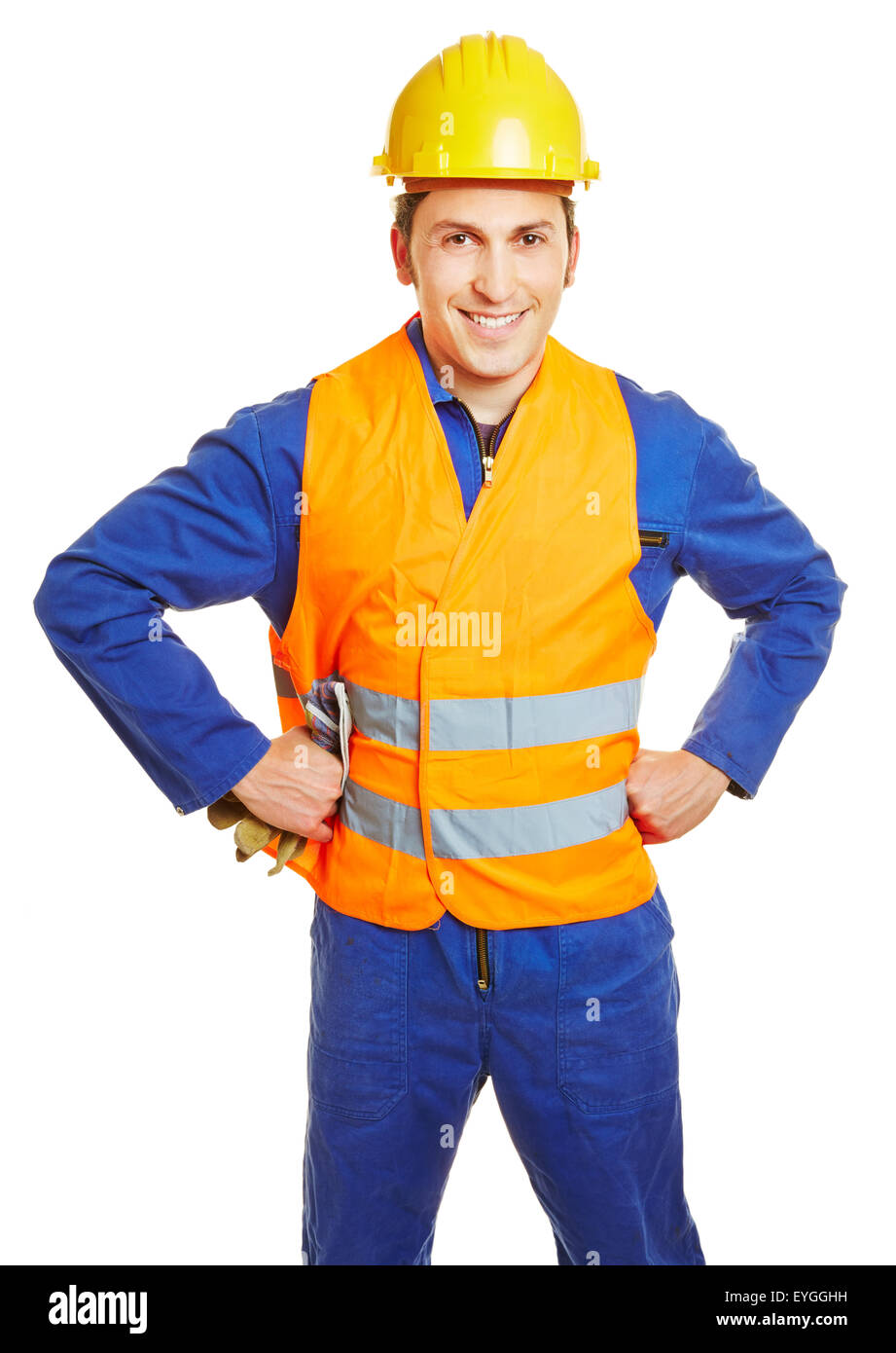 Sonriendo, trabajador de la construcción con casco y chaleco de seguridad y guantes de protección Foto de stock