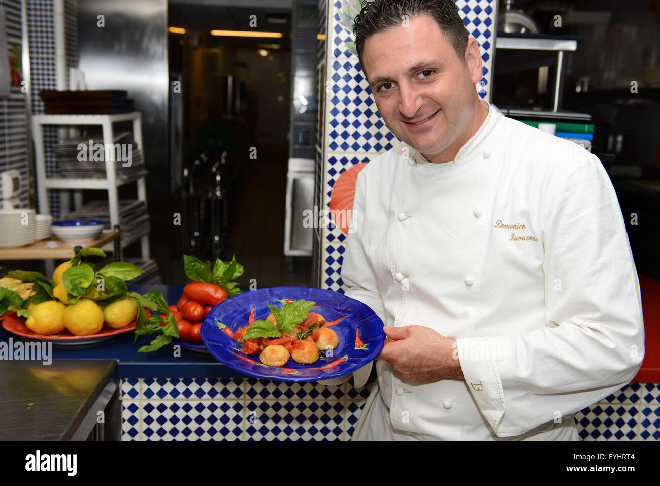 El chef Domenico Lavarone del Maxi restaurante presentando uno de sus platos de firma- Ravioles cocidos en salsa de San Marzano. Foto de stock