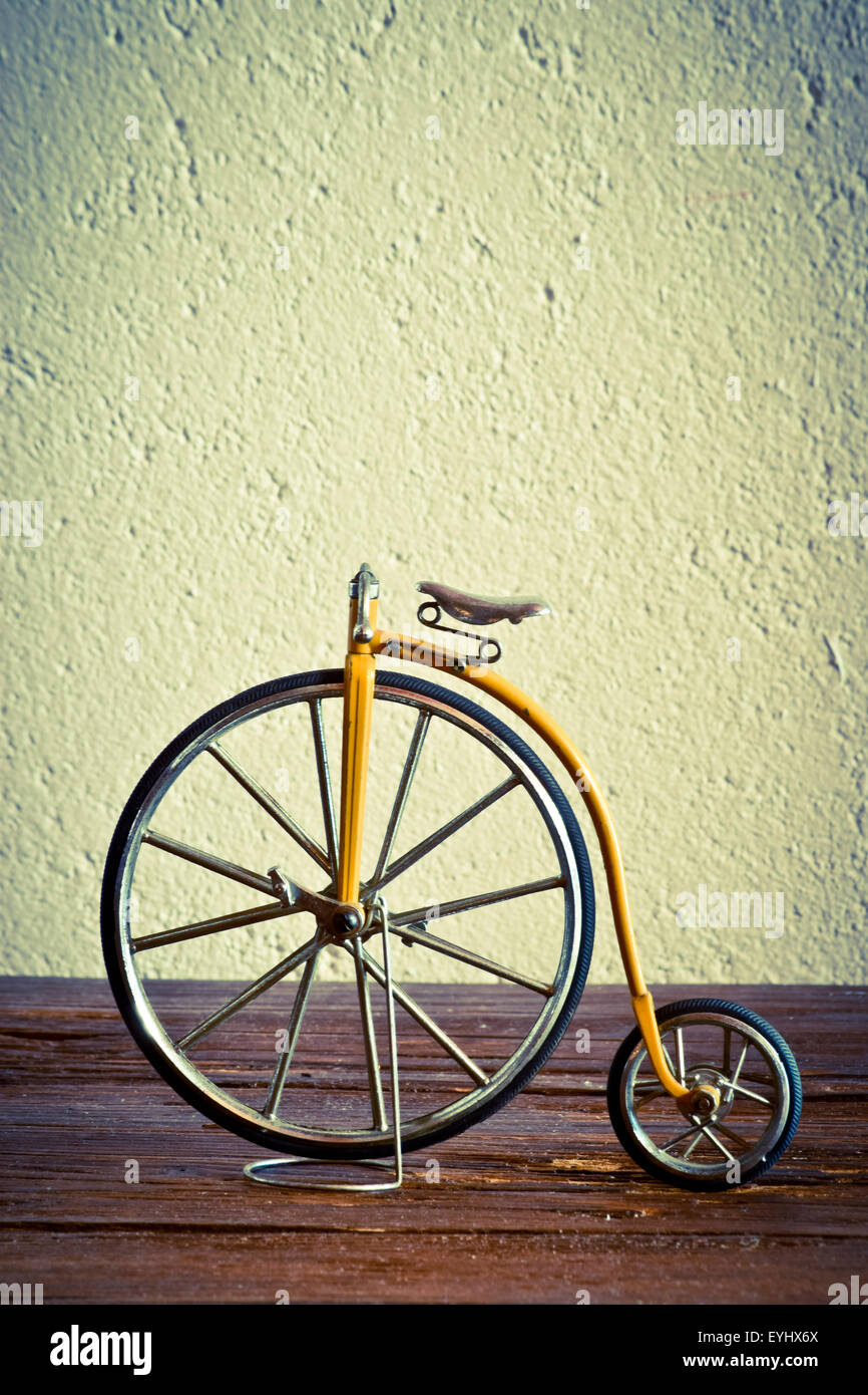 Vieja bicicleta con grande y pequeña rueda sobre una superficie de madera  Fotografía de stock - Alamy