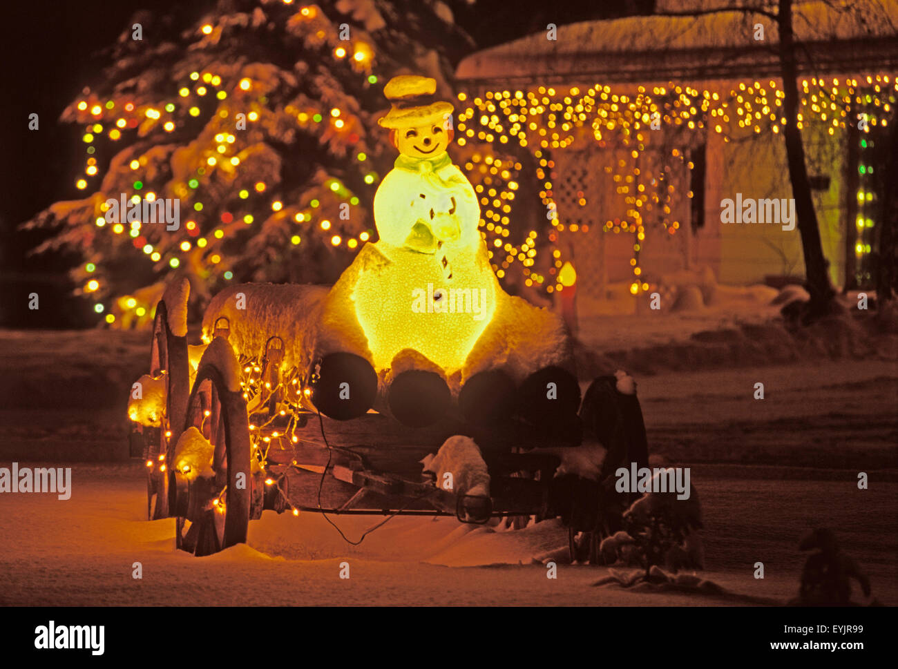 Weihnachts lichter mit schneemann auf altem holzwagen|luces de Navidad y el muñeco de nieve en el viejo vagón con registros Foto de stock