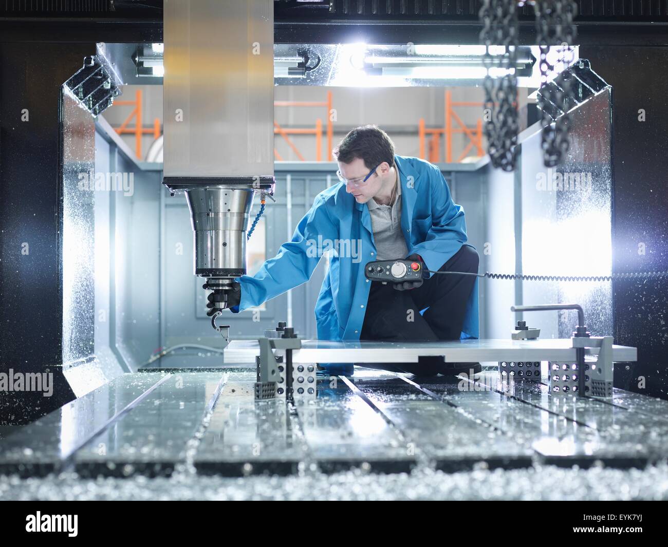 Trabajador en gran máquina CNC en fábrica de plásticos Foto de stock