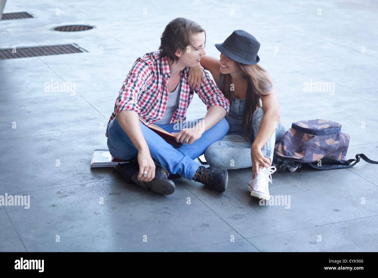 Pareja joven sentado en el suelo Foto de stock