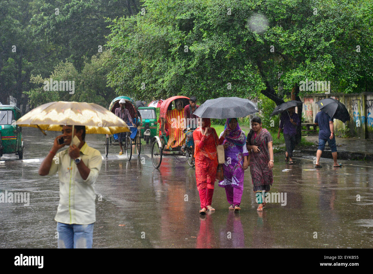 Dhaka, Bangladesh. El 31 de julio de 2015. Pueblos de Bangladesh despertando en la calle con sombrilla a través de tromba de agua causada por el debilitamiento de la tormenta tropical "Komen" en Dhaka, Bangladesh. El 31 de julio de 2015 Continua la lluvia moderada con gusty viento es probable que continúe hasta mañana causada por el debilitamiento de la tormenta tropical "Komen" en Dhaka y en otras partes del país, de acuerdo a Dhaka met office previsión. Crédito: Mamunur Rashid/Alamy Live News Foto de stock