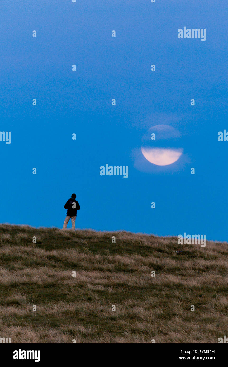 Mynydd Epynt, Powys, Reino Unido. El 23 de julio de 2015. Un 'Blue Moon' se eleva por encima de una colina walker en Mynydd Epynt altos páramos en Gales. Crédito: Graham M. Lorenzo/Alamy Live News. Foto de stock