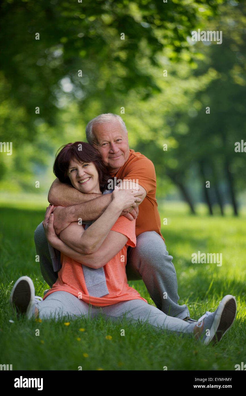 Pareja de ancianos, ropa deportiva, pradera, sentado, feliz, abrazo  Fotografía de stock - Alamy