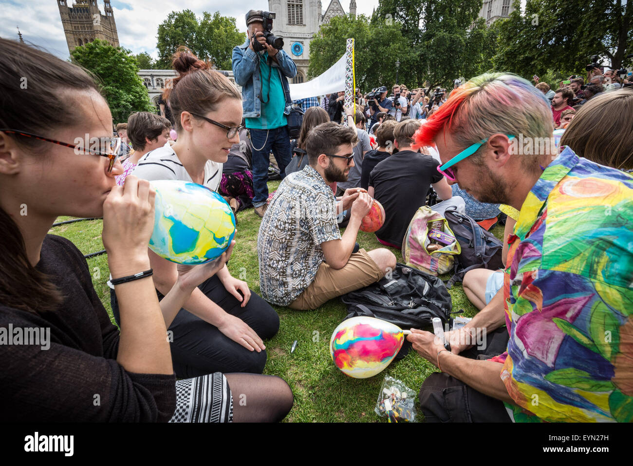 Londres, Reino Unido. El 1 de agosto de 2015. Los activistas inhalar globos inflados con óxido nitroso, conocido comúnmente como "gas de la Risa" para obtener alta durante una protesta en la Plaza del Parlamento de Westminster contra un proyecto de ley que apunta a hacer la venta de cualquier sustancia psicoactiva ilegal. Crédito: Guy Corbishley/Alamy Live News Foto de stock