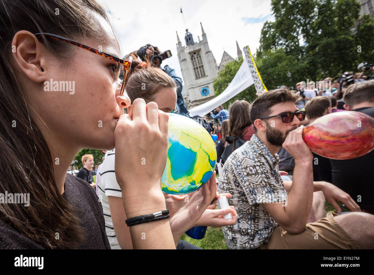 Londres, Reino Unido. El 1 de agosto de 2015. Los activistas inhalar globos inflados con óxido nitroso, conocido comúnmente como "gas de la Risa" para obtener alta durante una protesta en la Plaza del Parlamento de Westminster contra un proyecto de ley que apunta a hacer la venta de cualquier sustancia psicoactiva ilegal. Crédito: Guy Corbishley/Alamy Live News Foto de stock