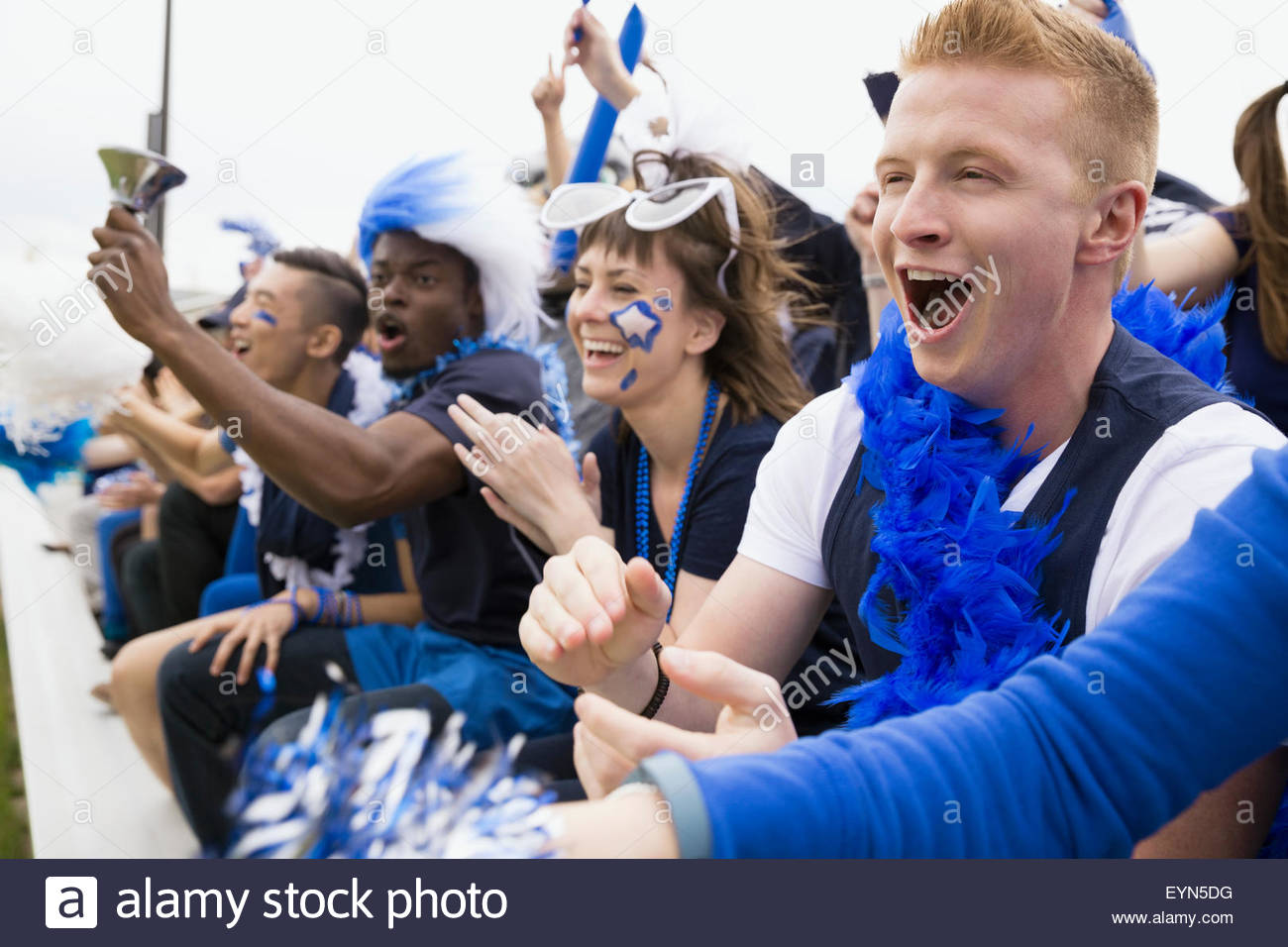 Entusiastas fans en azul vítores gradas evento deportivo Foto de stock