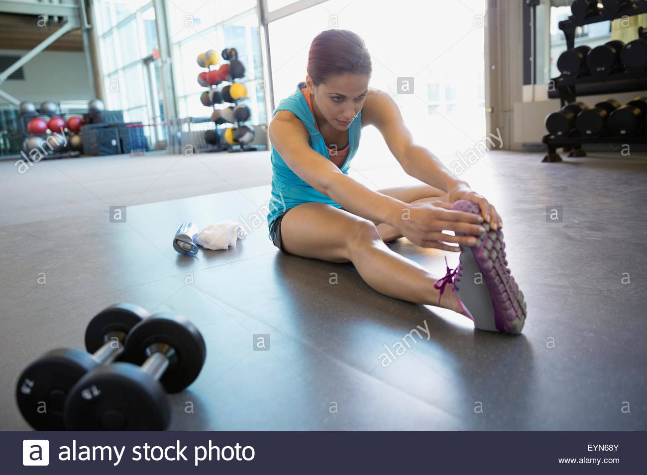 Mujer estirando la pierna en el gimnasio Foto de stock