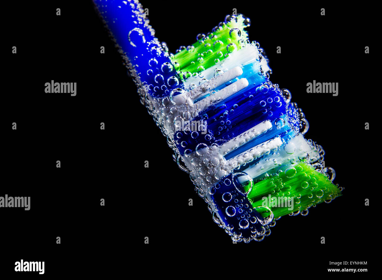 Cepillo de dientes con agua en el interior de la burbuja y aislado sobre fondo negro Foto de stock