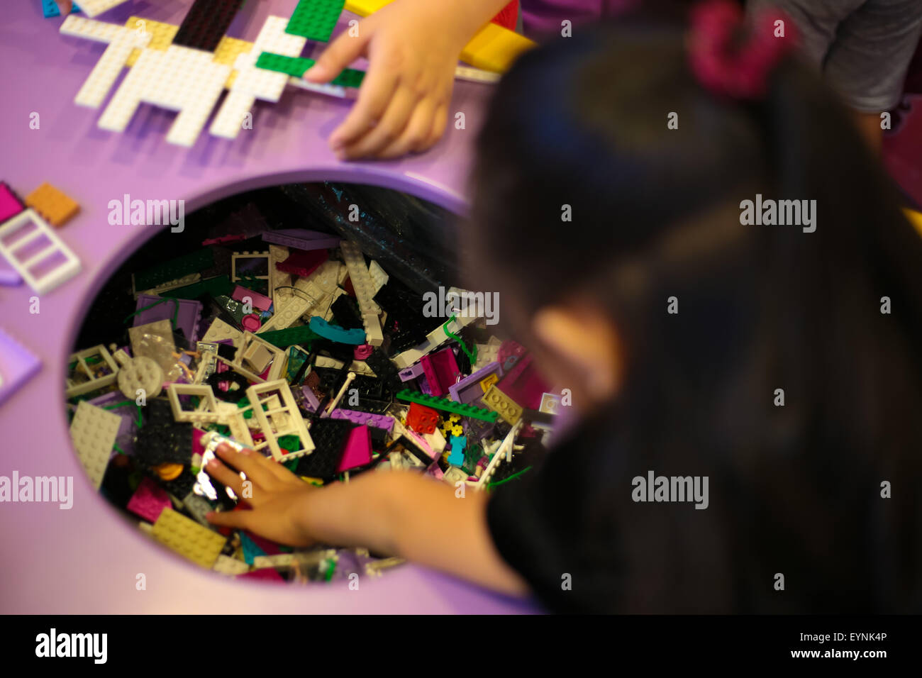 Los niños recogiendo piezas de lego en lego playtable para construir su  sueño de objeto Fotografía de stock - Alamy