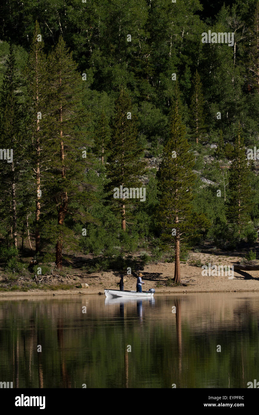 2 hombres pescando en un pequeño bote reflejada en un espejo, como el lago  temprano en la mañana una luz suave en el Rock Creek lake California  Fotografía de stock - Alamy
