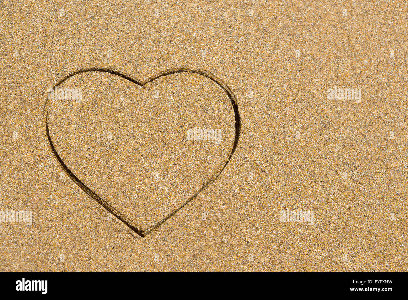 Forma corazón grabado en una playa de arena húmeda. Vacaciones de verano con antecedentes copyspace Foto de stock