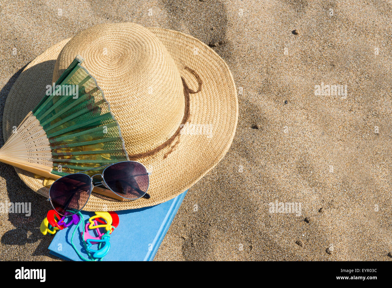 Sombreros de paja de verano, gafas de sol y un libro en la playa. Vacaciones de verano accesorios Foto de stock