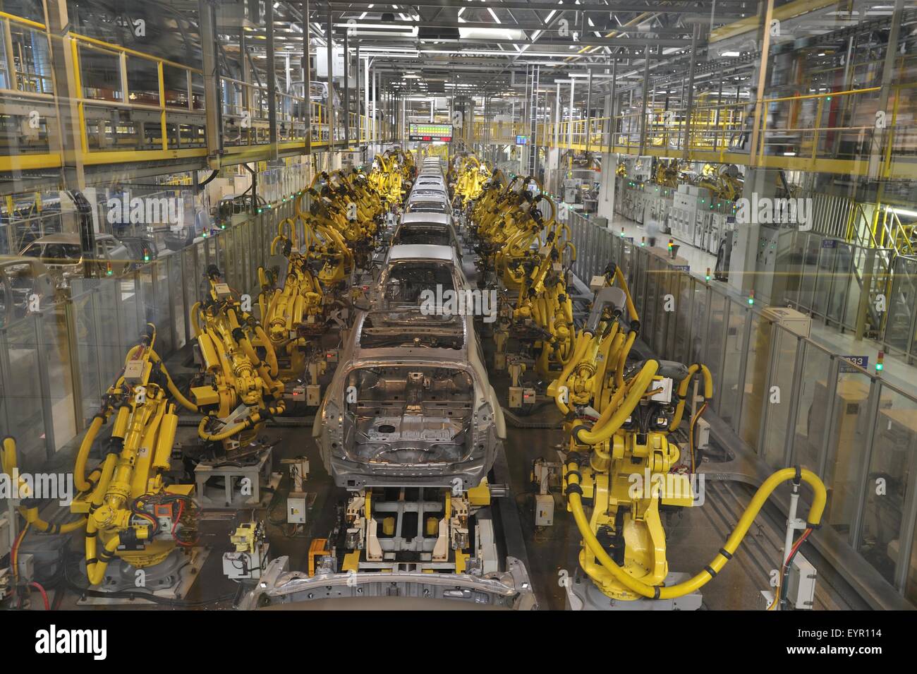 Dentro de una moderna fábrica de coches, vehículos y piezas se mueven a  través del proceso de producción, robots rodean las carcasas metálicas  desnudas Fotografía de stock - Alamy