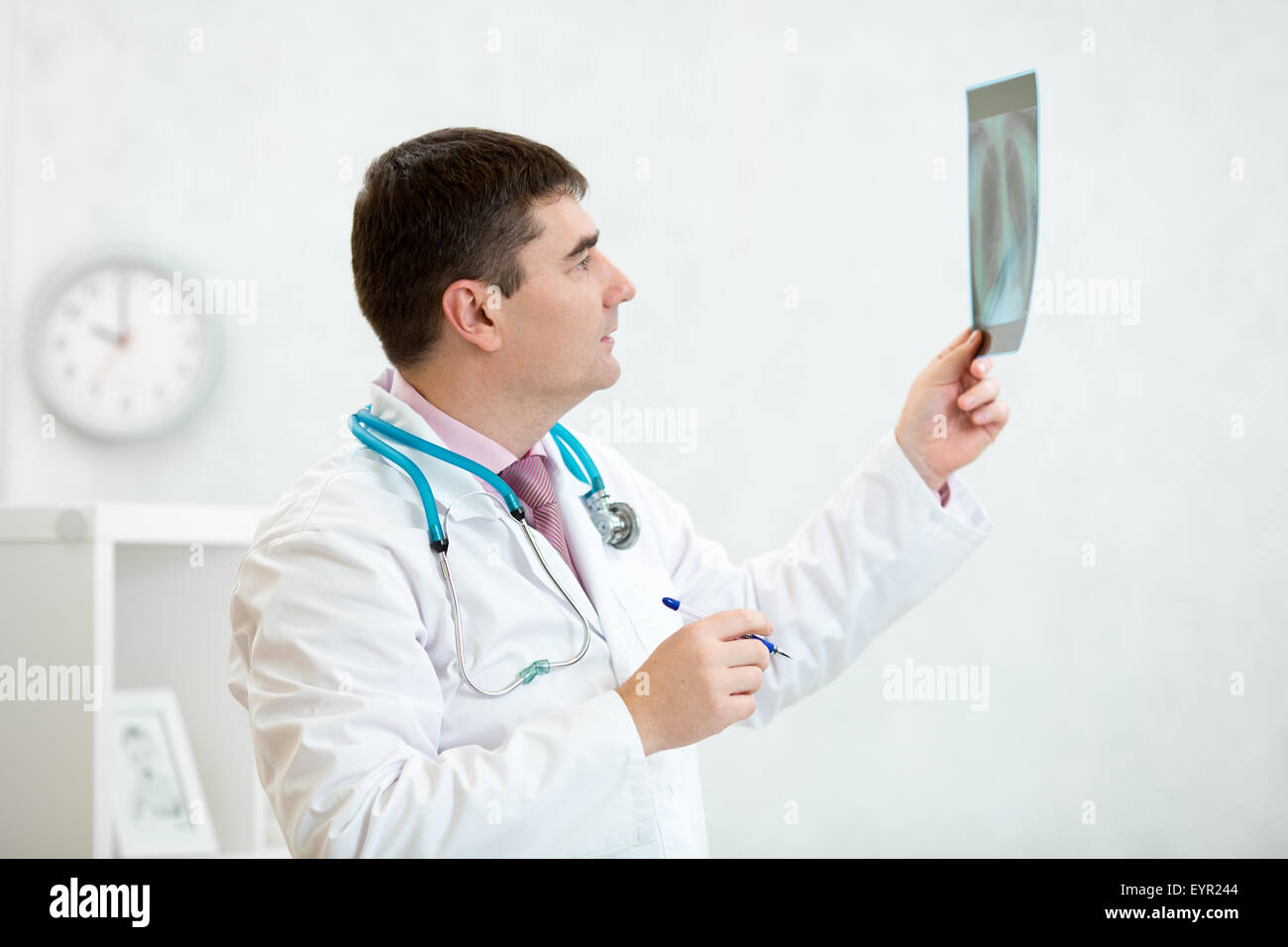 Médico examina una radiografía pulmonar Foto de stock