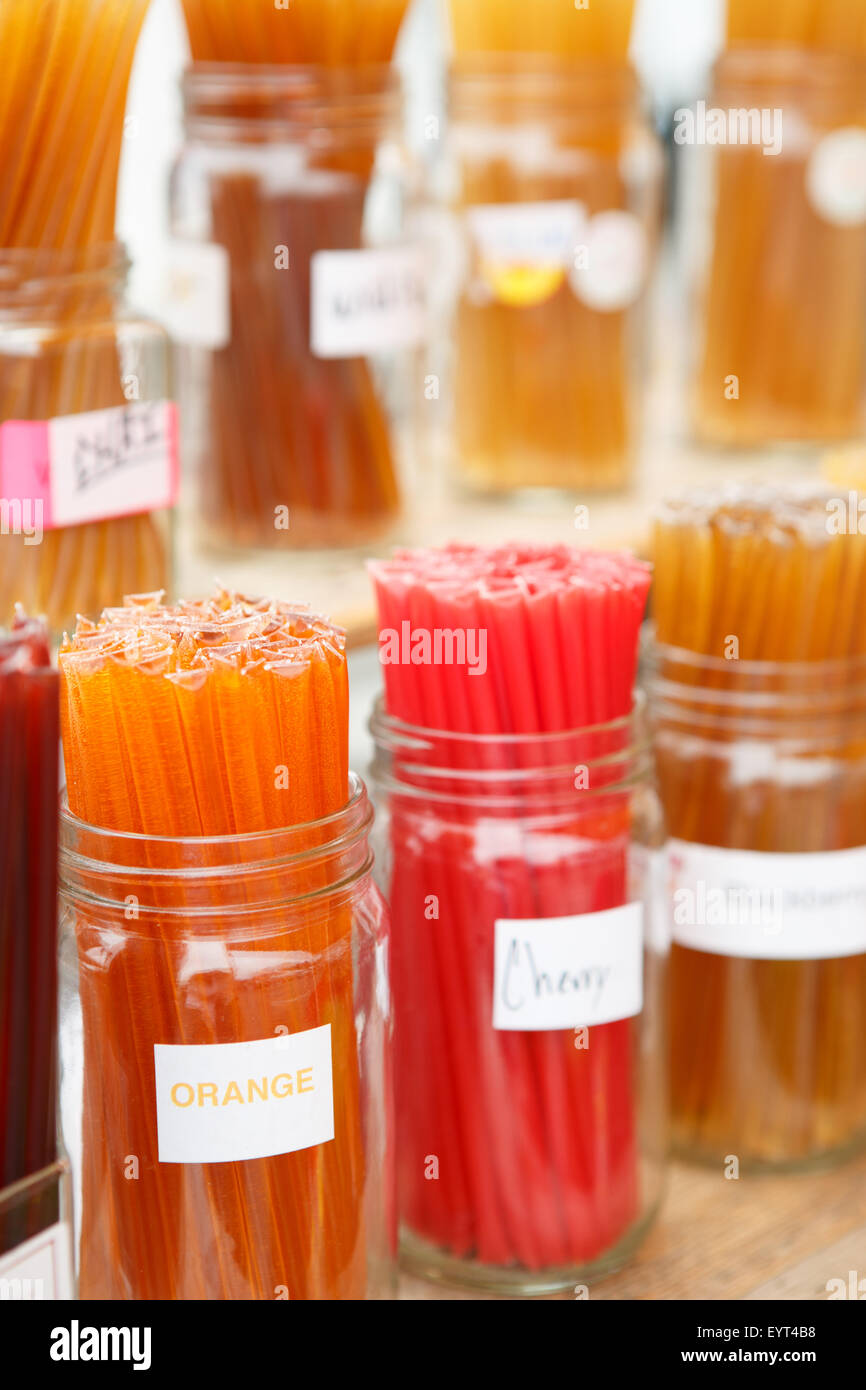 Cerca de coloridos sabores de miel en pajillas muestran en frascos en farmers market Foto de stock