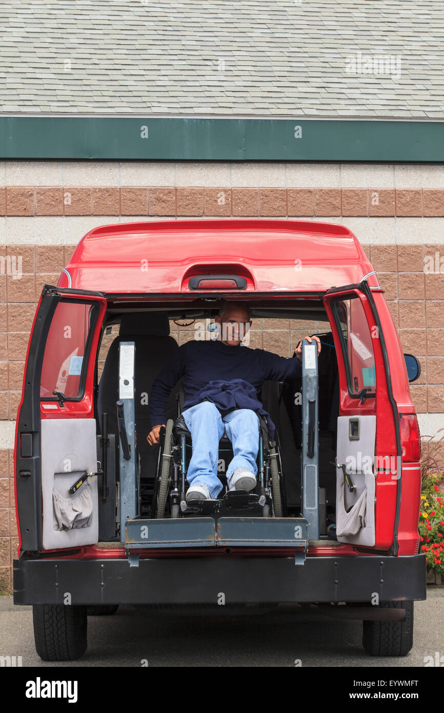 Hombre con una lesión de la médula espinal sale de su furgón accesible Foto de stock