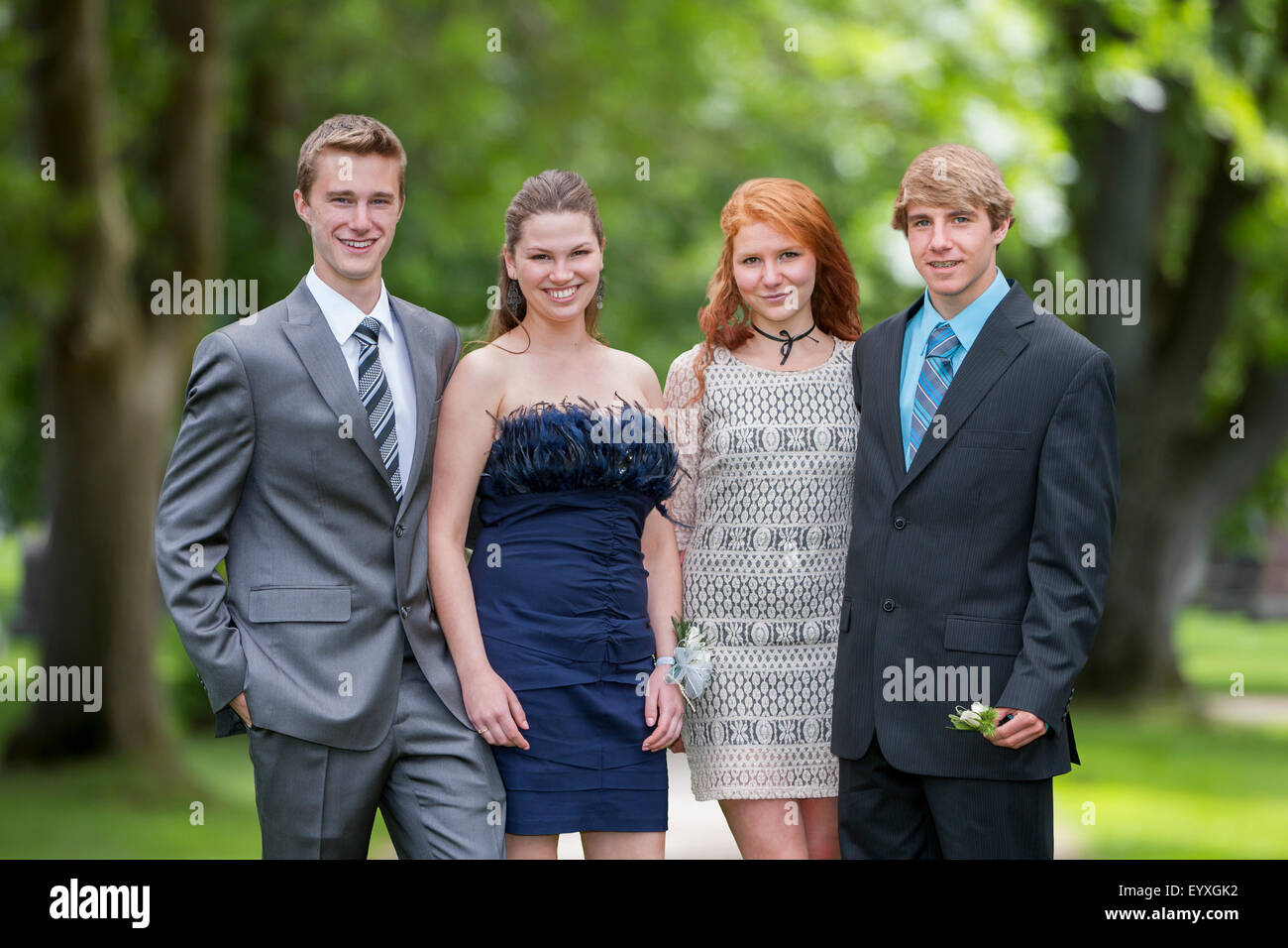 adolescentes varones y niñas de 18-19 años con ropa formal, posando ante el prom escolar Foto de stock