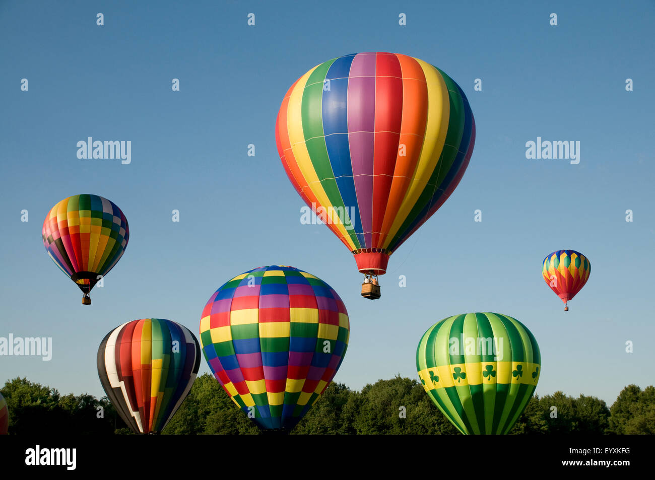 Varios globos de aire caliente con coloridos sobres ascendente o lanzar en un festival de globos aerostáticos Foto de stock