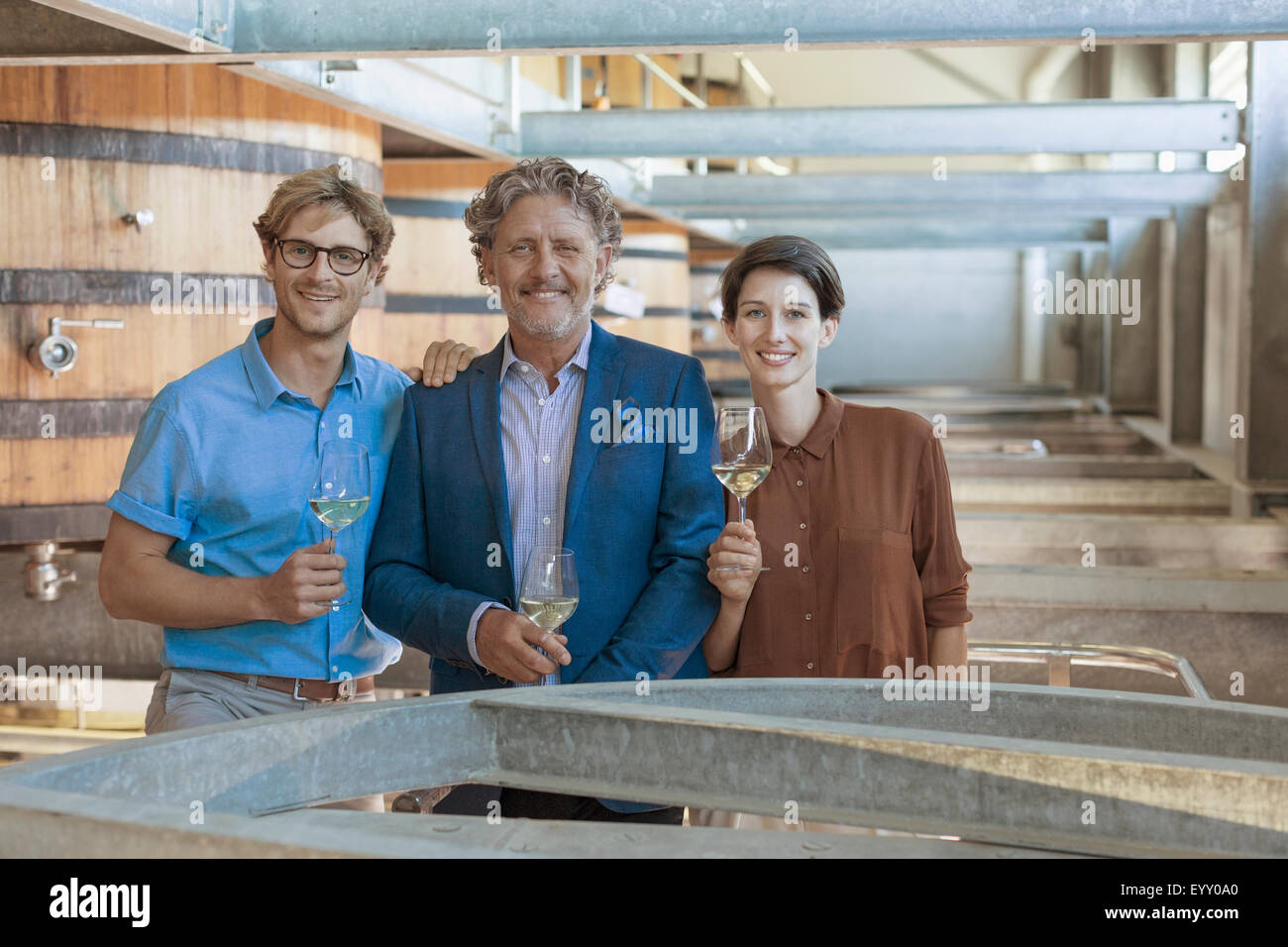 Retrato sonriente vintners con vino blanco en la bodega La bodega Foto de stock