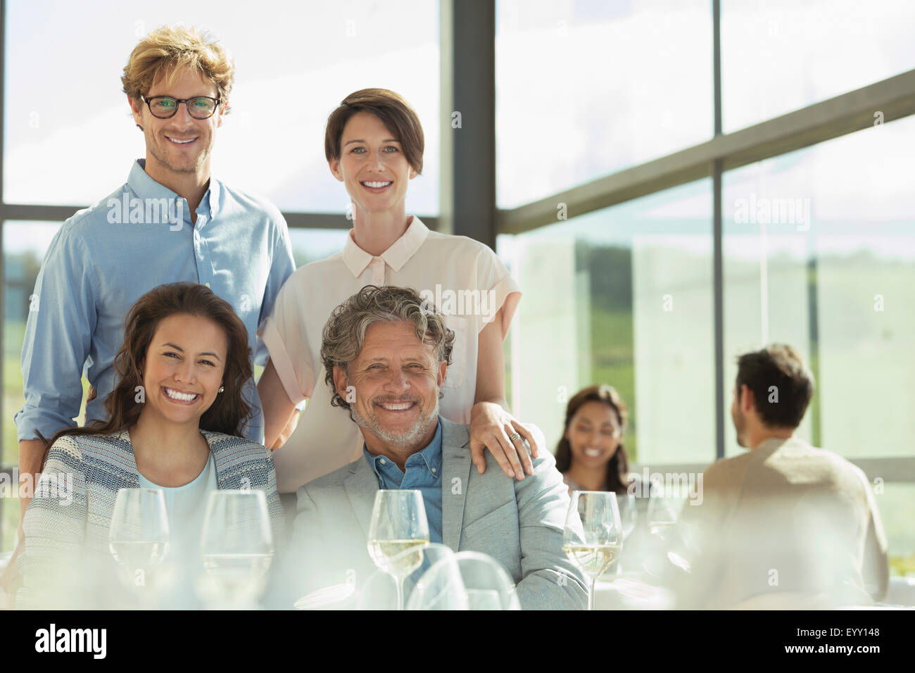 Retrato amigos sonrientes en el soleado restaurante Foto de stock
