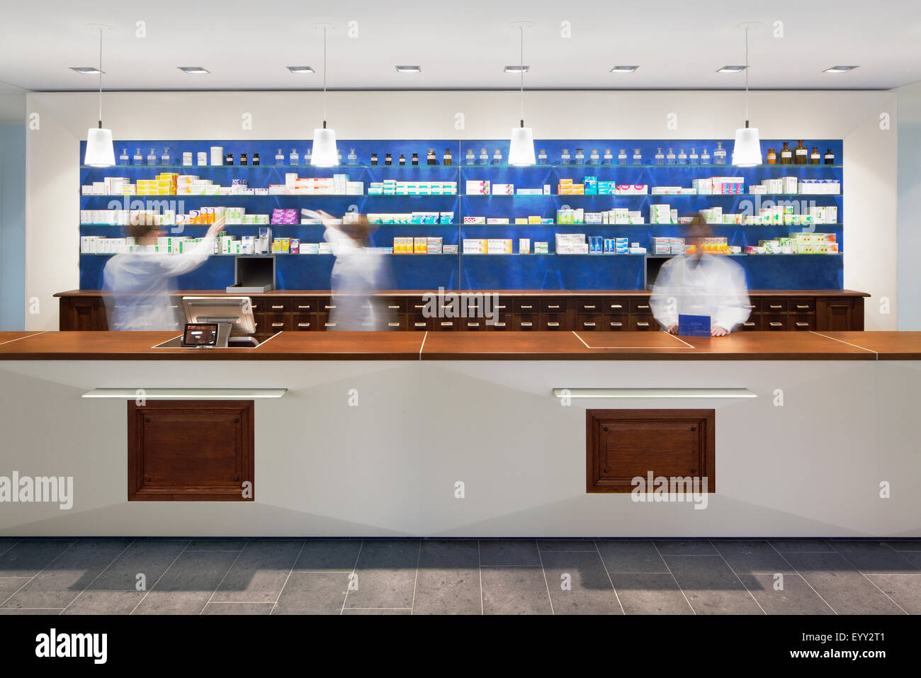Vista borrosa de farmacéuticos detrás del mostrador de la farmacia moderna Foto de stock