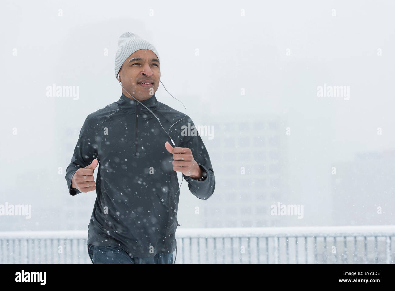 Black Runner jogging en la nieve Foto de stock