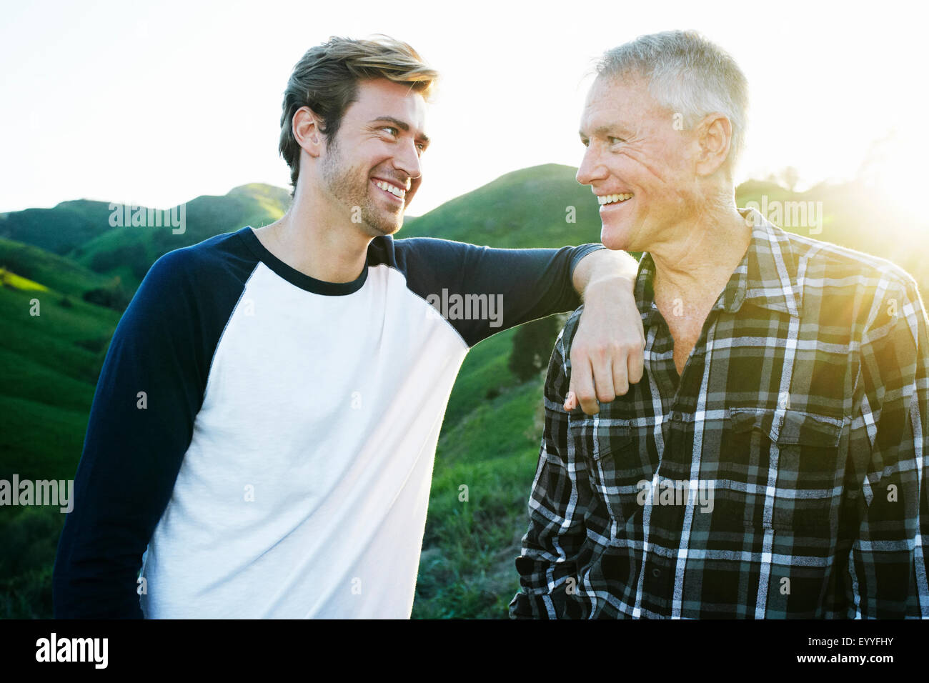 Padre e hijo del Cáucaso sonriendo en la cima de la colina rural Foto de stock