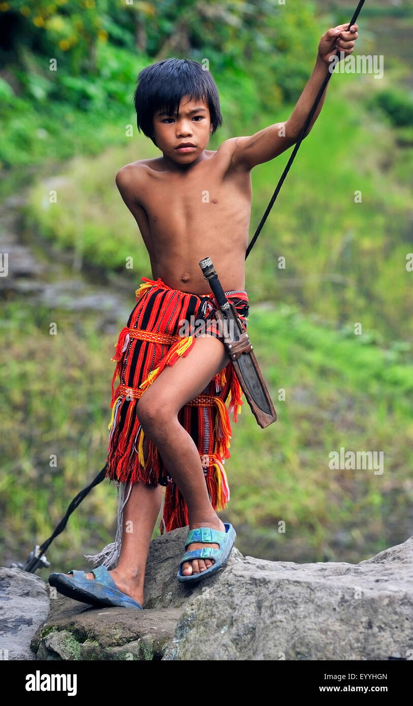 Niño de la tribu Ifugao en vestimentas tradicionales con machete, Filipinas, Luzón, Batad Foto de stock