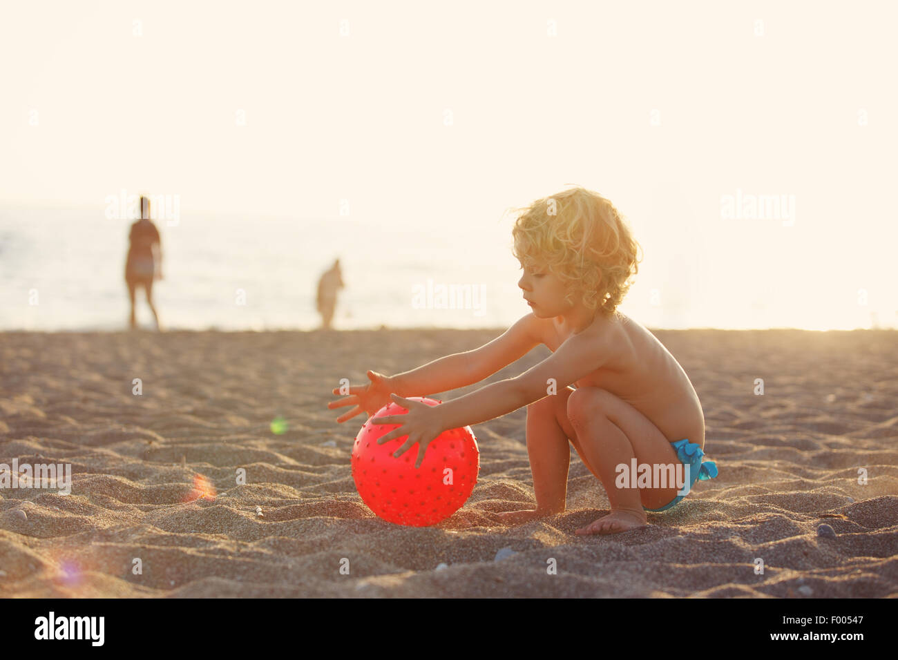 Vacaciones de Verano - niña jugando en la playa al atardecer Foto de stock
