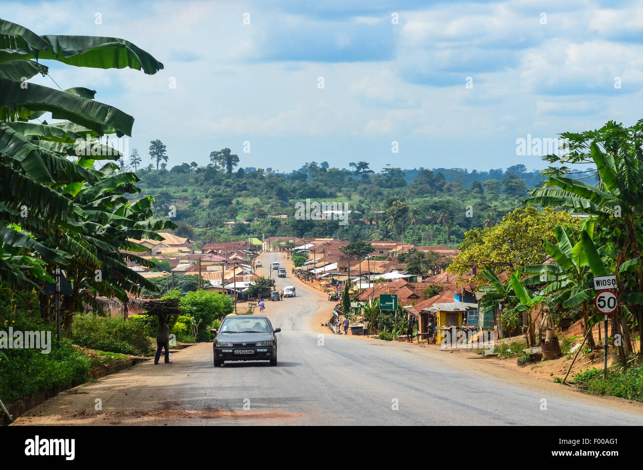 Vistas rurales de Ghana, un camino que cruza una aldea Foto de stock
