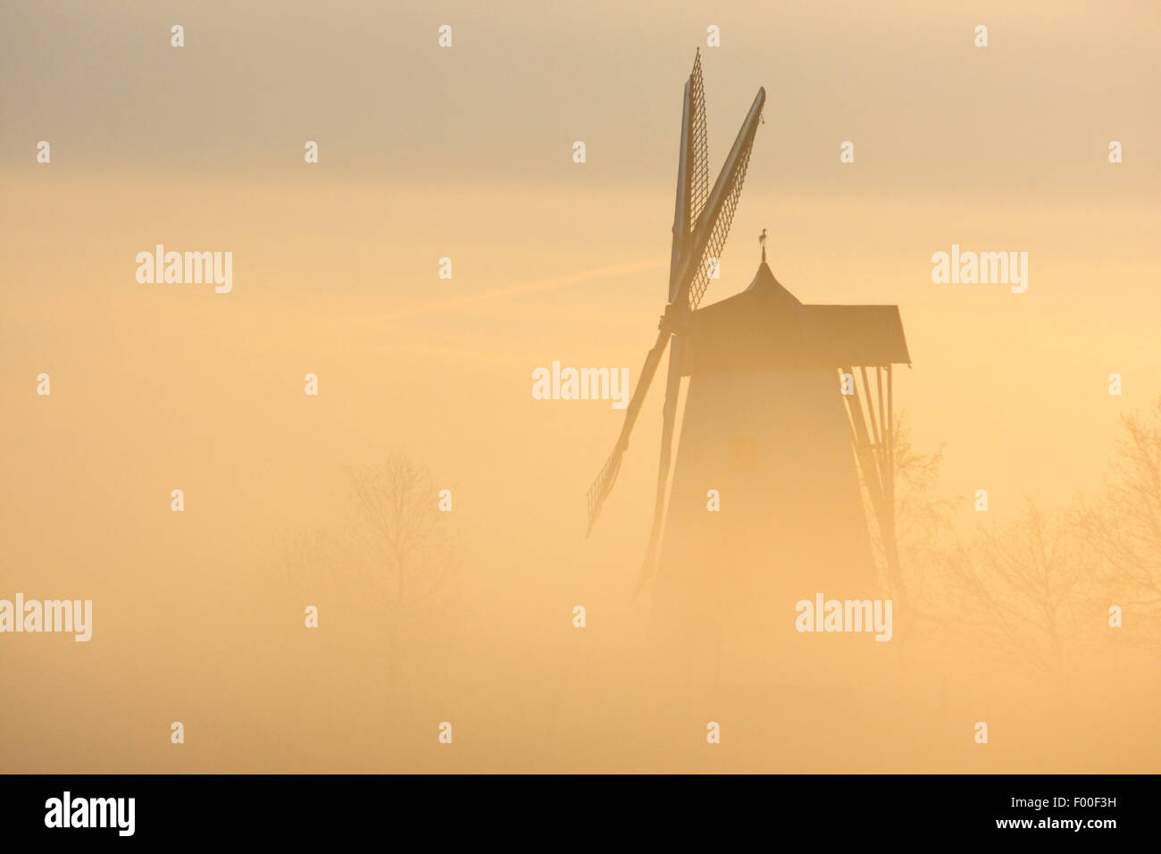 El molino de viento en la neblina al amanecer, Bélgica, las Ardenas Foto de stock
